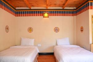 two beds in a room with wooden ceilings at Sinchula Villa in Paro