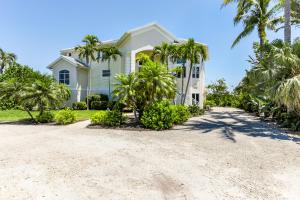 Royal Palm House في كابتيفا: منزل على الشاطئ مع أشجار النخيل