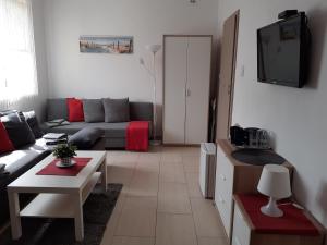 a living room with a couch and a tv at Villa Spokojna 26 in Mielno