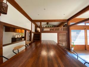a dining room with a large wooden table and chairs at Stay Sayu Hanok in Gyeongju
