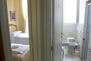 un bagno con lavandino e una camera con due letti di Piazza Argento a Lecce Altre 37 foto