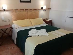 a bedroom with a large bed with two towels on it at Renacer in Federación