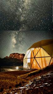 une tente sous un ciel nocturne avec un ciel étoilé dans l'établissement Desert star camp, à Wadi Rum