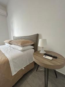 um quarto com uma cama e uma mesa com controlo remoto em PeoniaRooms em Aprilia