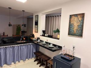 a bar in a room with a counter and chairs at Deck Hospedaria in Cunha
