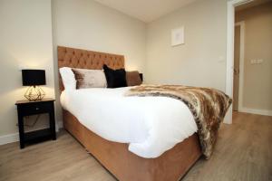 ein Schlafzimmer mit einem großen Bett und einem Tisch mit einer Lampe in der Unterkunft Casablanca 3 - Cardiff Bay - 2 Bed Apartment in Cardiff