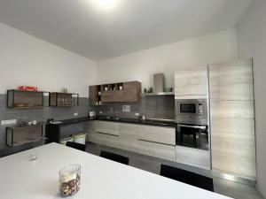 eine große Küche mit einem weißen Tisch darin in der Unterkunft PeoniaRooms in Aprilia