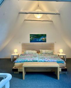 a bedroom with a large bed in a attic at Ferienapartment Kastanje in Groß Ippener