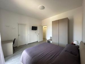 ein Schlafzimmer mit einem Bett und einem Fernseher in der Unterkunft PeoniaRooms in Aprilia