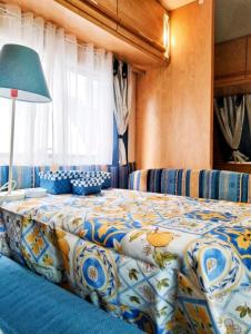 a bedroom with a bed with a blue and white comforter at Sweet Camper in Florence