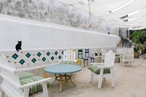 un café avec des chaises, une table et un chat sur le mur dans l'établissement CENTRO DE LA CIUDAD CASA PAXI ESTUDIO8, à Mérida 14 autres photos