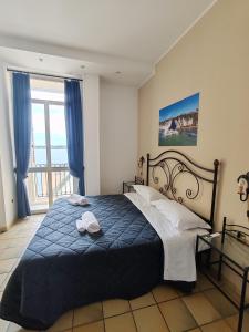 una camera con letto e piumone blu di Life Hotels Residence dei Baroni a Siracusa