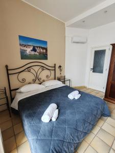 a bedroom with a blue bed with two towels on it at Life Hotels Residence dei Baroni in Syracuse