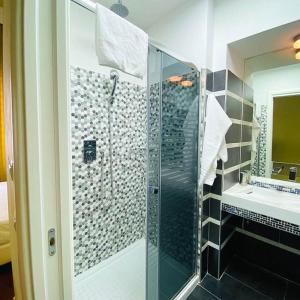 a bathroom with a glass shower and a sink at Relais Villa Coppedè in Rome