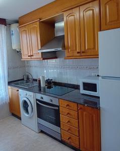 坎加斯德穆拉索的住宿－Pura Playa - Rías Baixas - Galicia，厨房配有白色冰箱和洗碗机。