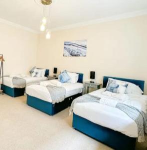 três camas num quarto com paredes brancas em Quaint 3BR l Market St Watford l Sleeps 8 em Watford
