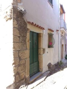 una porta verde sul lato di un edificio di Casa vacanze Sa Rocchitta a Querce