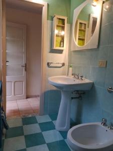 a bathroom with a sink and a toilet and a mirror at Casa vacanze Sa Rocchitta in Querce