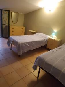 um quarto com duas camas e um espelho em Casa vacanze Sa Rocchitta em Querce