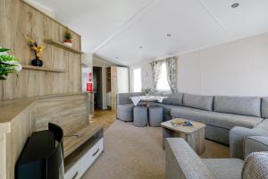 sala de estar con sofá y TV en 10 Beachlands, en Porchfield
