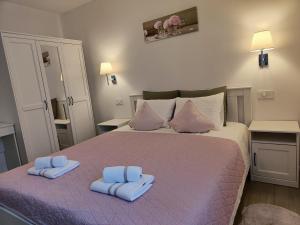 a bedroom with a large bed with blue towels on it at Apartments Vodaric in Cres