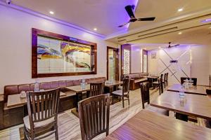 a restaurant with tables and chairs and a couch at Townhouse 1239 Grand Inn in Ghaziabad
