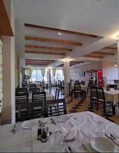 a dining room with white tables and chairs and a restaurant at Vila Megi in Golem