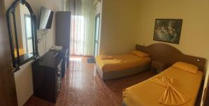 a hotel room with two beds and a television at Vila Megi in Golem