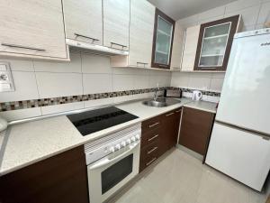 a kitchen with a sink and a stove top oven at Rinconada Real Benidorm in Benidorm