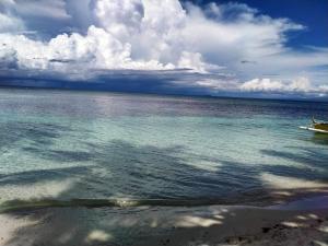 a view of the ocean with a boat in the water at Beachfront Guesthouse Siquijor in San Juan