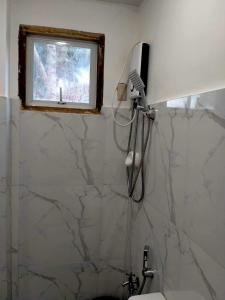 a bathroom with a shower and a sink and a window at Beachfront Guesthouse Siquijor in San Juan