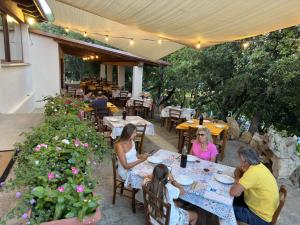 un groupe de personnes assises à une table dans un restaurant dans l'établissement Agriturismo Piperedda, à Irgoli