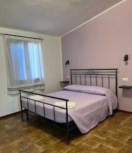 a bedroom with a bed and a window at Bidd’e Majori in San Priamo