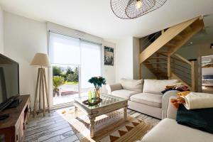 a living room with a couch and a table at Villa avec piscine privée, sauna, jardin et parking in Barneville-Carteret