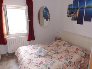a bedroom with a bed with a towel on it at Apartman Karmela in Zaton