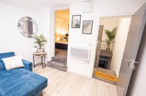 a living room with a blue couch and a table at Quaint 3BR l Market St Watford l Sleeps 8 in Watford