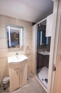 La salle de bains est pourvue d'un lavabo et d'une douche. dans l'établissement Quaint 3BR l Market St Watford l Sleeps 8, à Watford