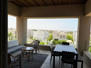 un soggiorno con divano, tavolo e sedie di Hacienda Bay Chalet Sidi Abdelrahman North Coast a El Alamein