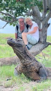Due donne sedute su un albero con un alligatore di Jhuna Komodo Homestay a Komodo