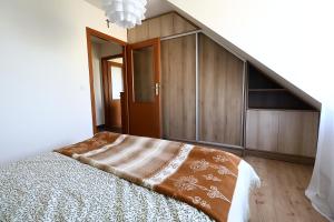 1 dormitorio con 1 cama y armarios de madera en Rabczański Apartament, en Rabka-Zdroj