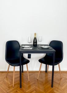 una mesa negra con 2 sillas y 2 copas de vino en Apartment Mirochka, en Belgrado