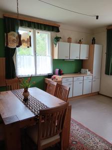 a kitchen with a wooden table and a dining room at Urlaub am Bauernhof in Trattenbach
