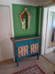 a blue dresser with a mirror on a green wall at Urlaub am Bauernhof in Trattenbach