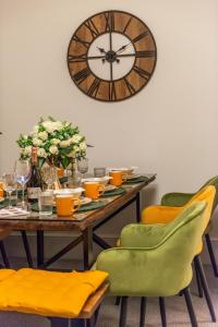 uma mesa com cadeiras e um grande relógio na parede em Stylish Spacious Retreat Luxury 2 Bedroom Haven 2 em Londres