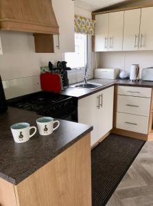 una cocina con 2 tazas de café en la barra en Turnberry Holiday Home en Turnberry