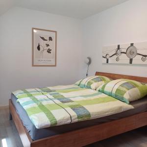 a bedroom with a bed with a green and yellow comforter at Ferienhaus mit 4 Schlafzimmer in Pansdorf