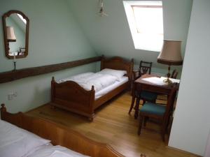 a bedroom with two beds and a table and a mirror at Penzion Záhornice 