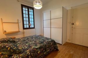 1 dormitorio con cama y ventana grande en Tous au jardin, calme, centre à 10min à pied!, en Montceau-les-Mines