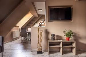 a living room with a table and a tv on the wall at Laza napok apartman - 1 in Veszprém