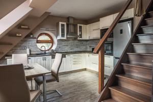 a kitchen with stairs leading up to a loft at Laza napok apartman - 1 in Veszprém